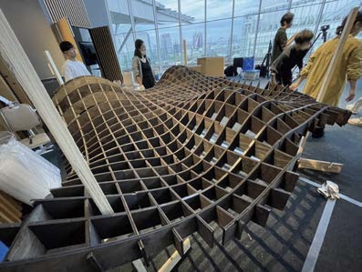 木組みの火棚を組み立てる日本科学未来館の展示設営風景